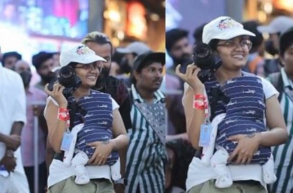 Kerala Woman taking photos with baby in her shoulder