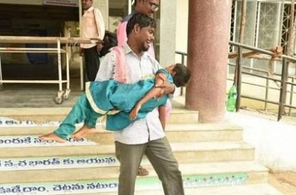 Man carries child in hands after being denied an ambulance