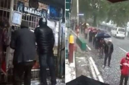men stands out of liquor shops in brave hailstorm