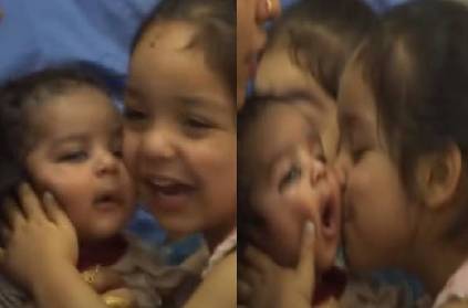 afghan child kisses infant in joy after reaching india